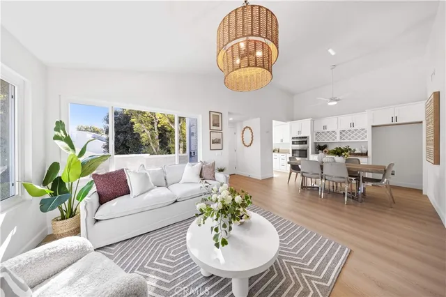 a living room with furniture kitchen view and a large window