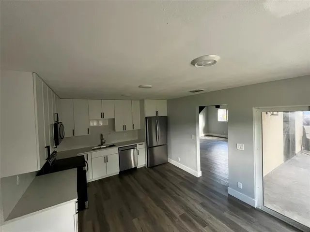 a kitchen with stainless steel appliances a sink a stove a refrigerator and cabinets