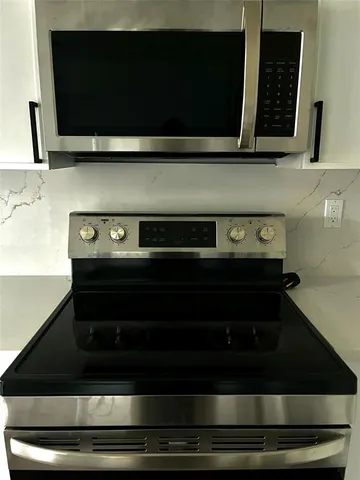 a bathroom with a microwave stove and cabinets