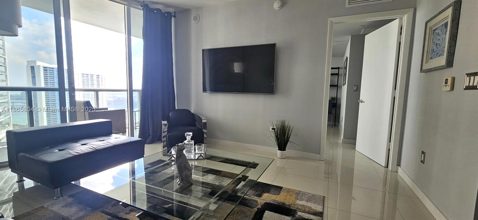 495 Brickell Avenue, Unit 3308 Miami, FL 33131 - Photo 5 of 15 a living room with furniture and a flat screen tv