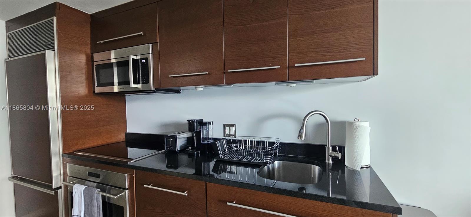 495 Brickell Avenue, Unit 3308 Miami, FL 33131 - Photo 10 of 15 a kitchen with a sink and cabinets