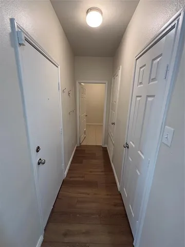 a view of empty room with kitchen and window