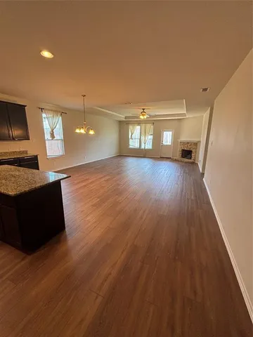 a view of kitchen with kitchen island wooden floor and stainless steel appliances