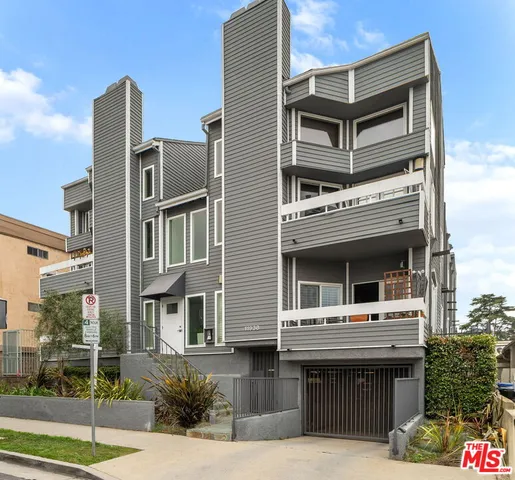 a front view of a house with a garden and plants