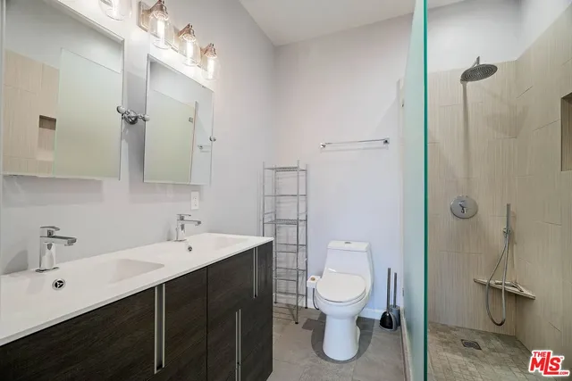 a bathroom with a toilet sink a mirror and shower