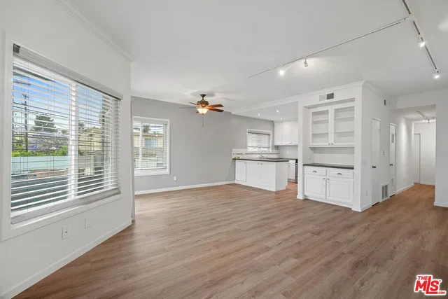 a view of a kitchen with wooden floor and windows