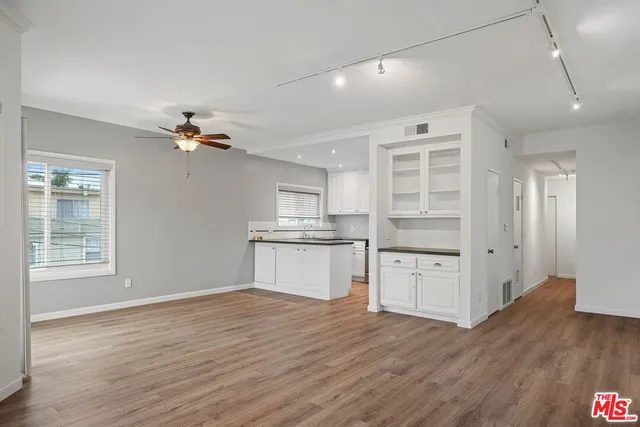 a kitchen with granite countertop white cabinets and stainless steel appliances