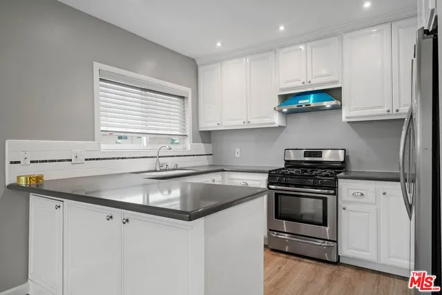 a kitchen with stainless steel appliances granite countertop a sink stove and cabinets