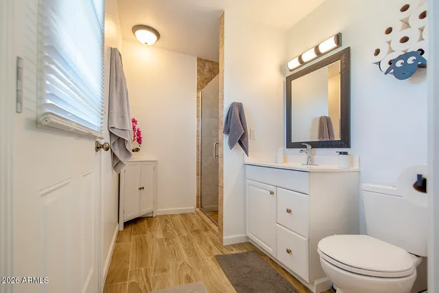 a bathroom with a granite countertop sink toilet and shower