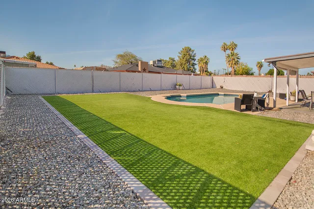 a swimming pool with outdoor seating and yard