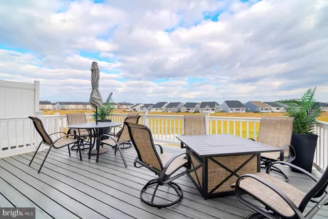 a view of a roof deck with table and chairs