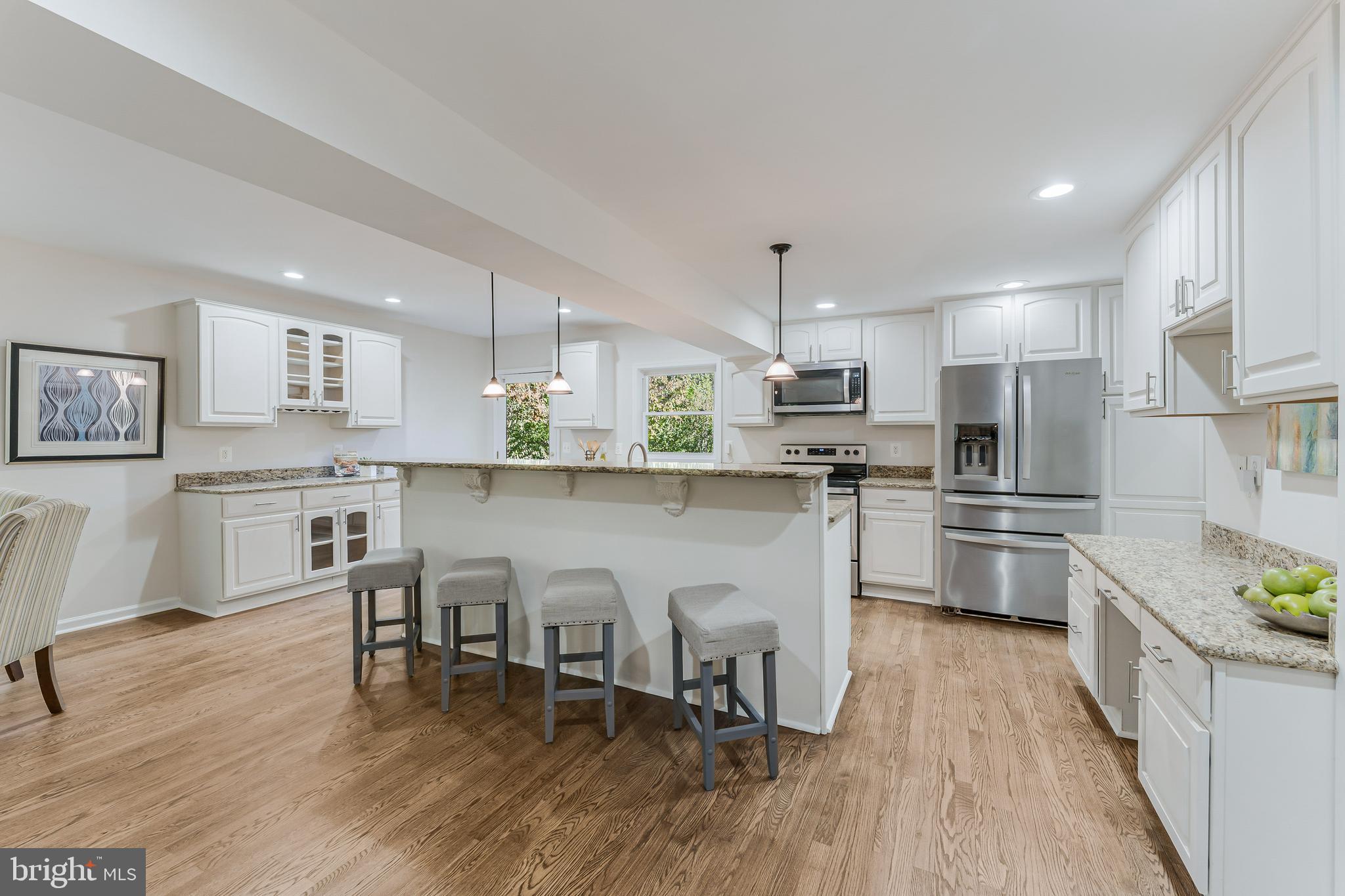 13430 Hidden Meadow Court Herndon, VA 20171 - Photo 13 of 54 a kitchen with stainless steel appliances granite countertop a table chairs microwave and sink