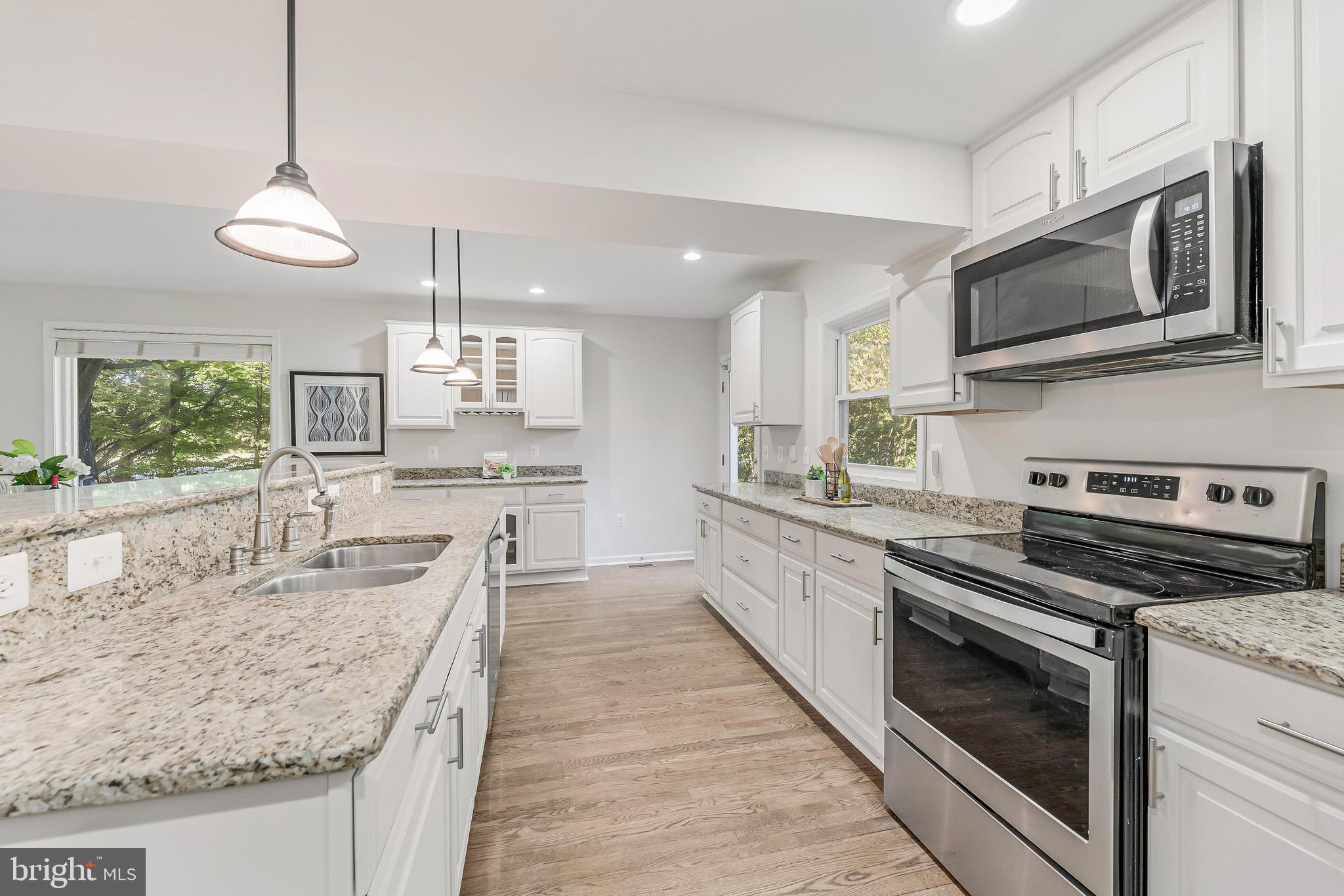 13430 Hidden Meadow Court Herndon, VA 20171 - Photo 16 of 54 a large kitchen with granite countertop a stove and a sink