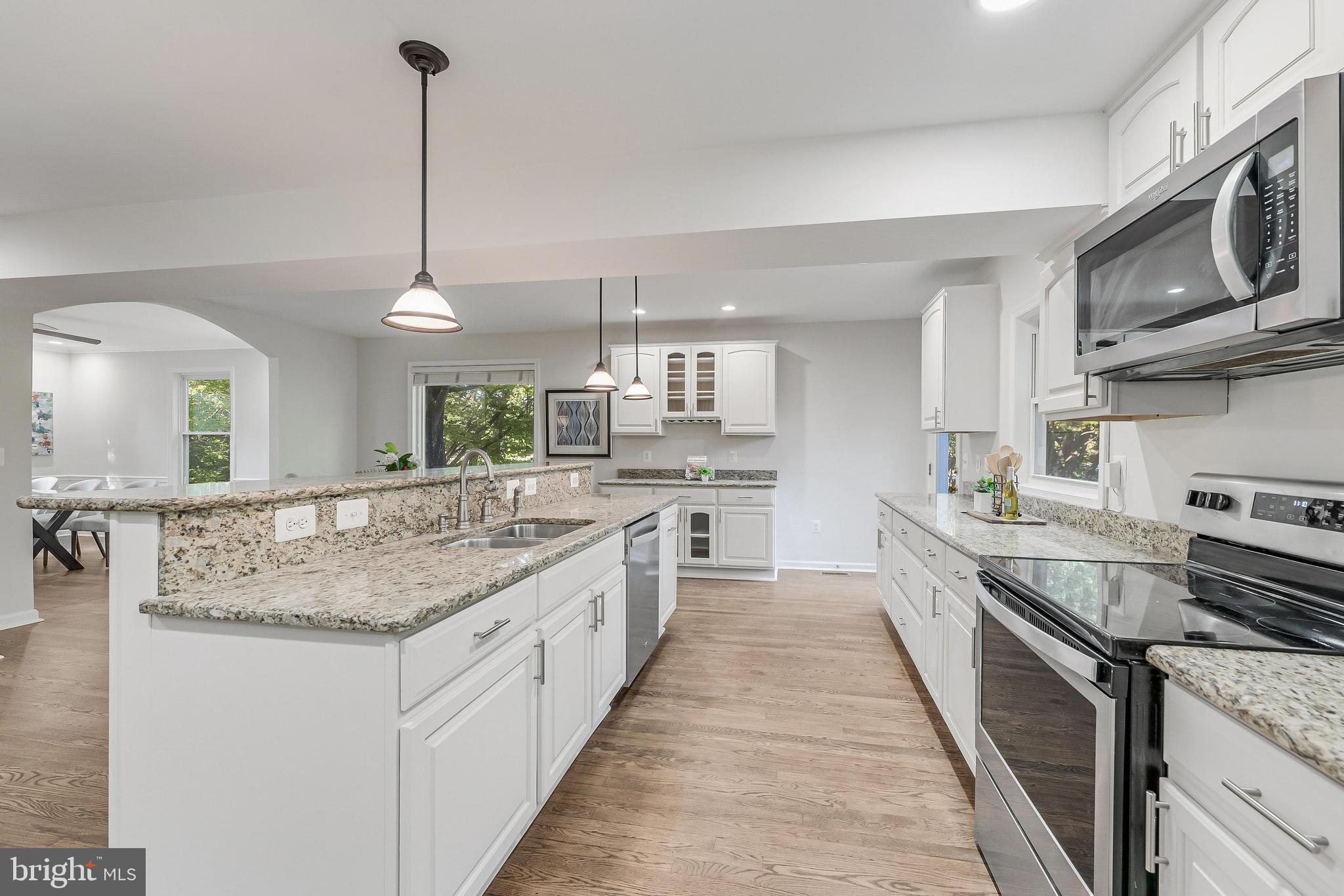 13430 Hidden Meadow Court Herndon, VA 20171 - Photo 17 of 54 a kitchen with stainless steel appliances granite countertop a sink a stove and a wooden floor