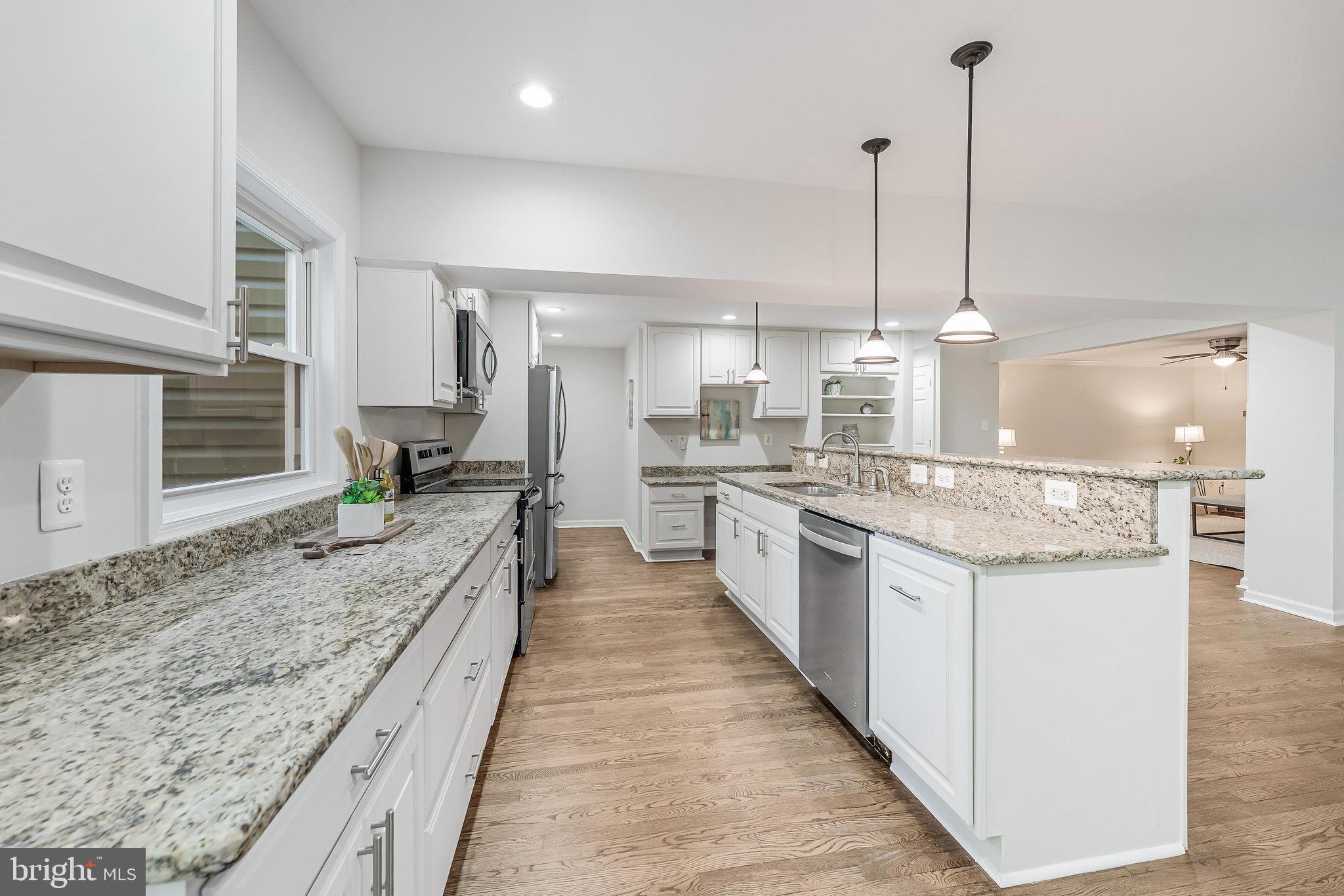 13430 Hidden Meadow Court Herndon, VA 20171 - Photo 18 of 54 a large kitchen with kitchen island a sink stove and wooden floor