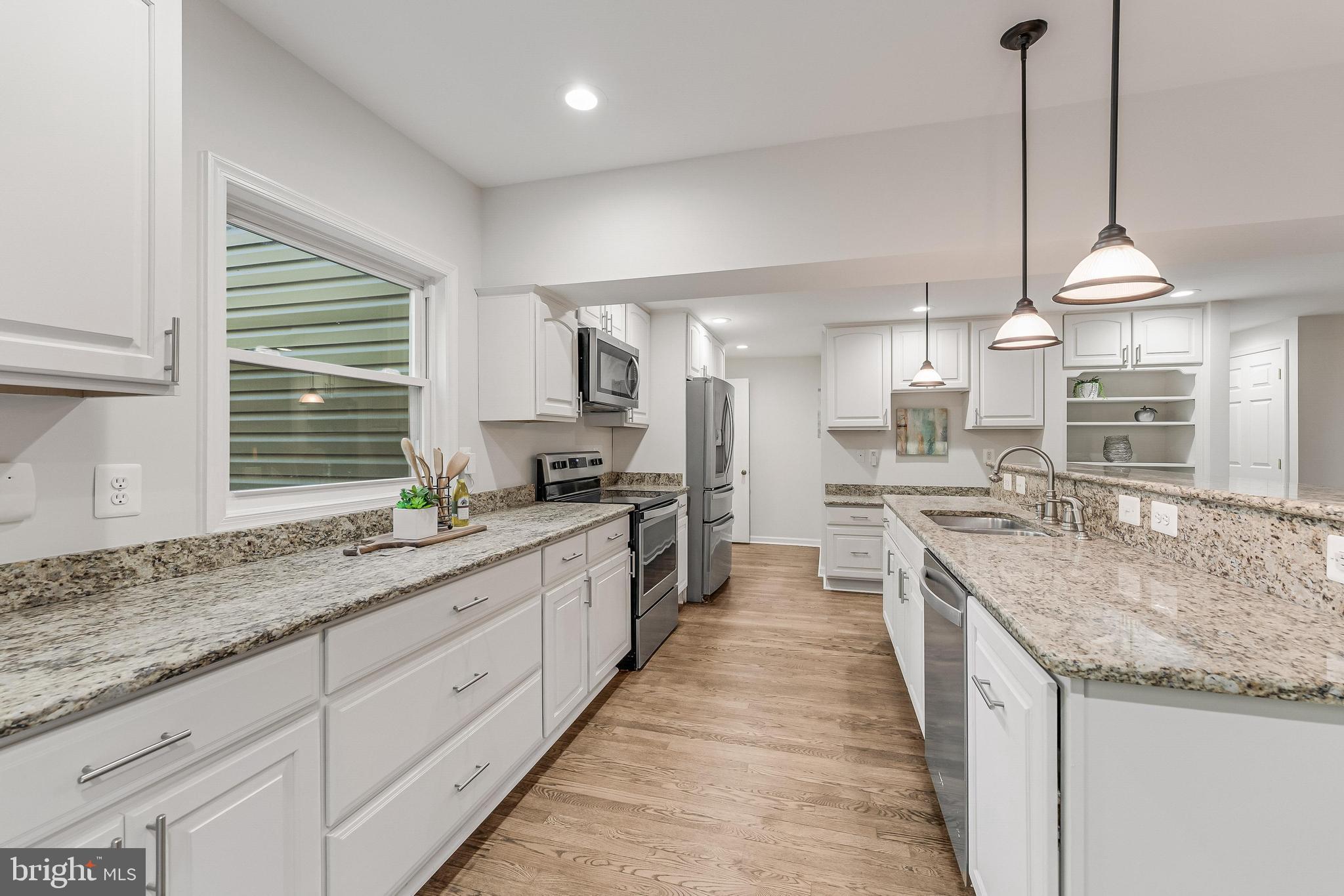 13430 Hidden Meadow Court Herndon, VA 20171 - Photo 19 of 54 a large kitchen with granite countertop a sink and a wooden floor