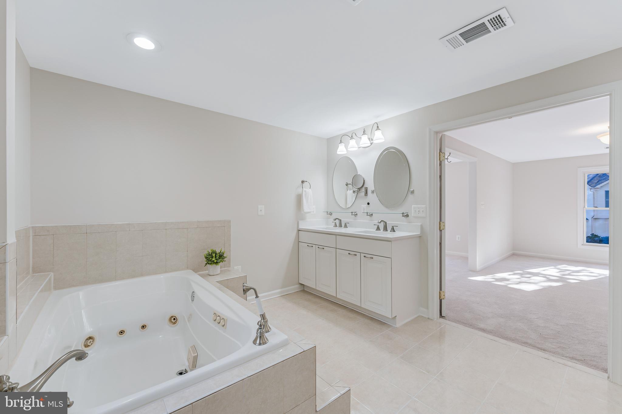 13430 Hidden Meadow Court Herndon, VA 20171 - Photo 35 of 54 a bathroom with a bathtub a mirror a double vanity sinks and vanity