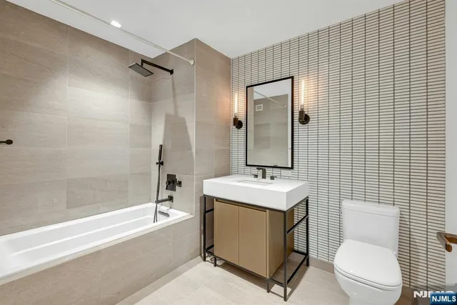 a bathroom with a toilet a sink a mirror and bathtub