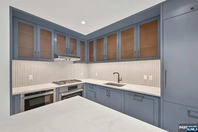 a kitchen with a sink a stove and cabinets