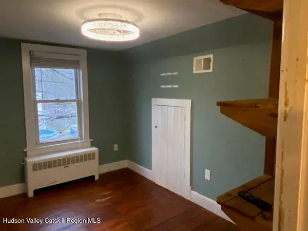 a view of a room with wooden floor and a window