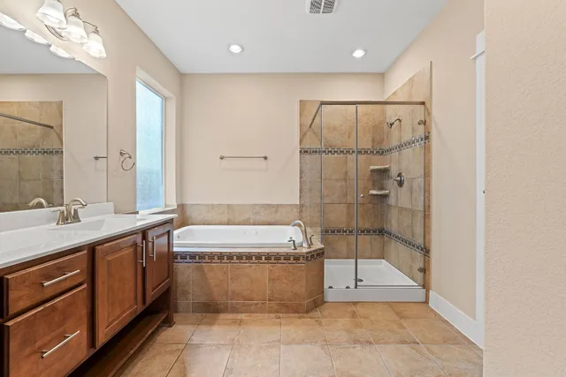 a spacious bathroom with a double vanity sink a large mirror and shower