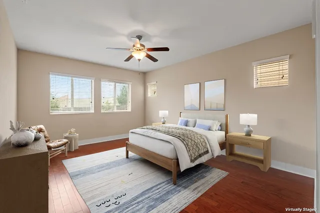 a spacious bedroom with a bed and wooden floor