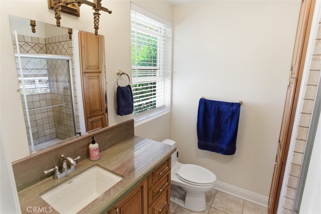31233 Romero Canyon Road Castaic, CA 91384 - Photo 27 of 38 a bathroom with a granite countertop toilet a sink and a mirror