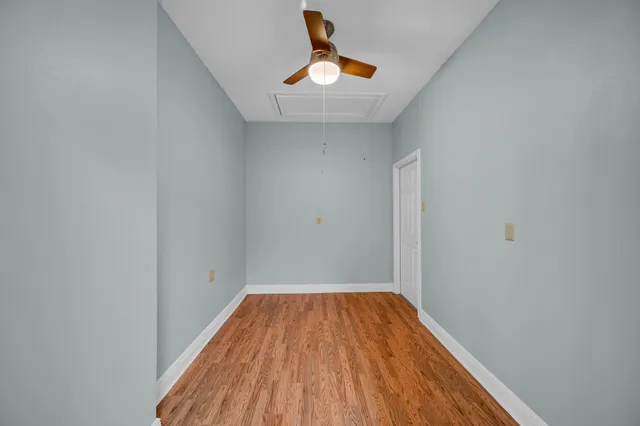 an empty room with ceiling fan and window