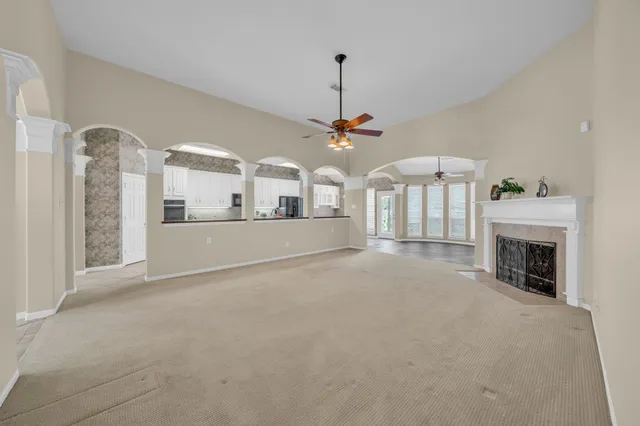an empty room with a window and a chandelier fan