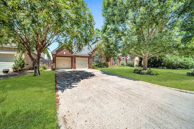 a front view of a house with a yard and trees