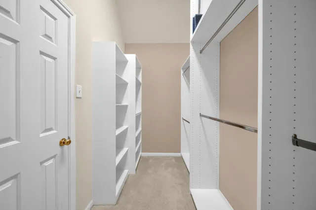 a view of a big room with a chandelier fan and windows