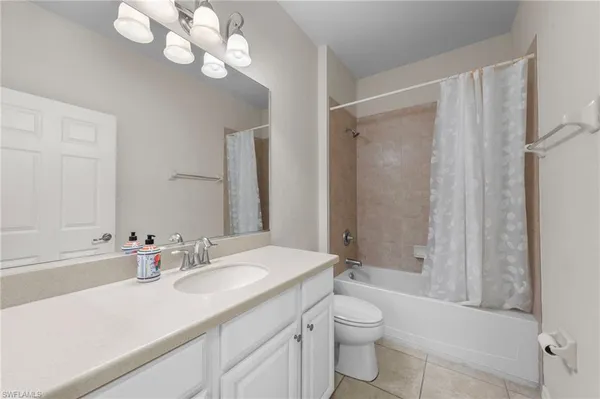 a bathroom with a sink a toilet and a large mirror