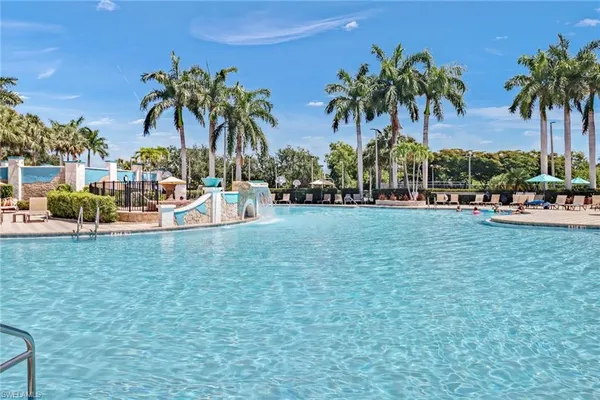 a row of palm trees and swimming pool in the backyard of a house