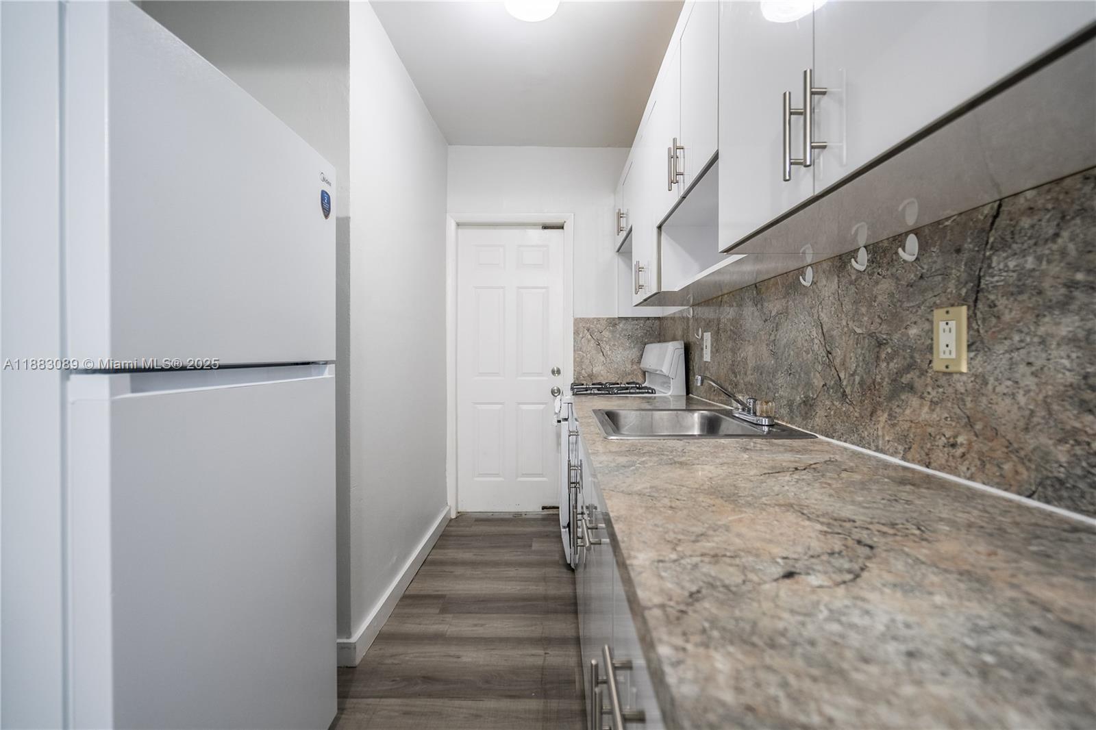 1190 71st Street, Unit 9 Miami Beach, FL 33141 - Photo 7 of 15 a view of a hallway with wooden floor and staircase
