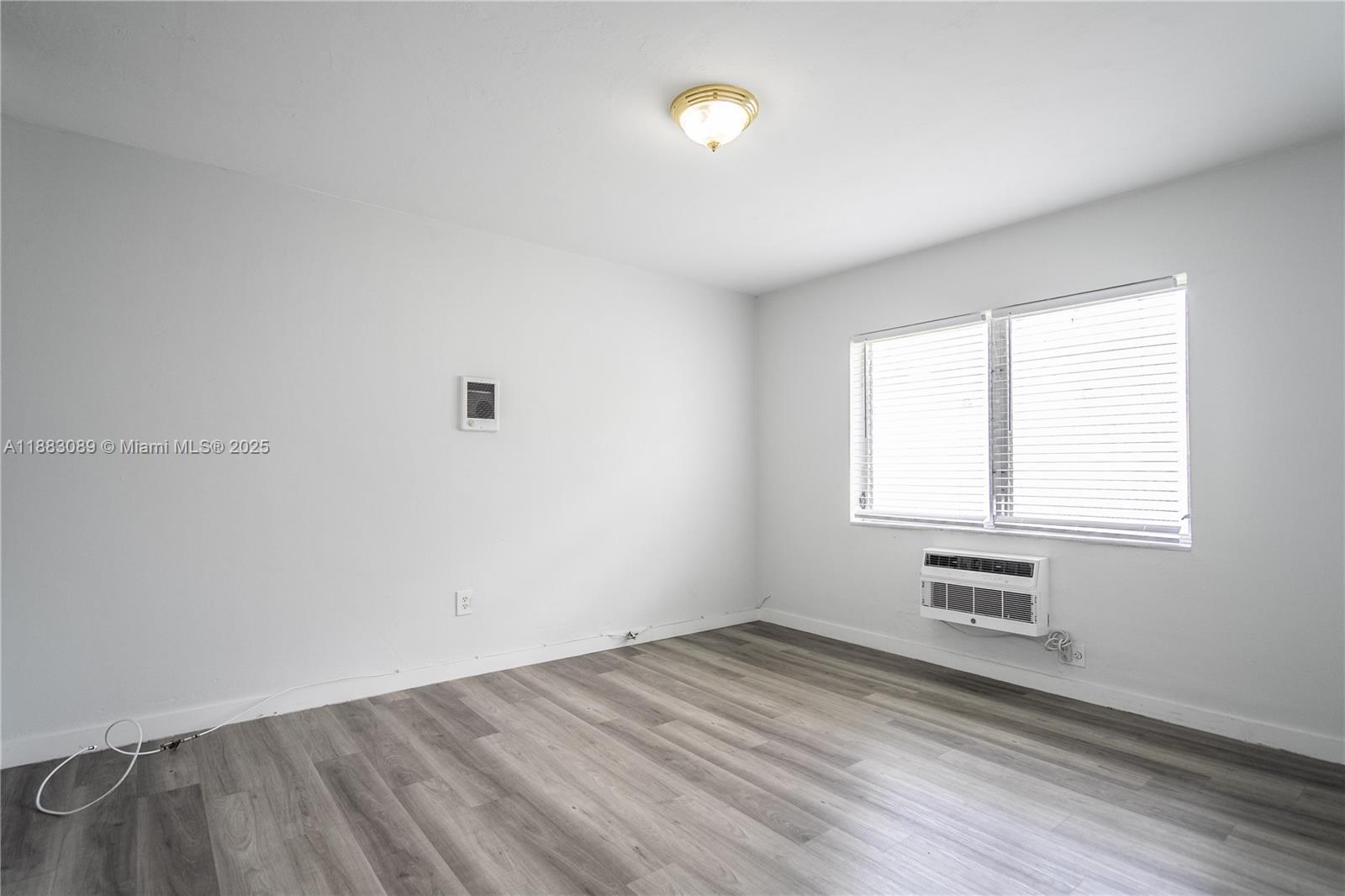 1190 71st Street, Unit 9 Miami Beach, FL 33141 - Photo 9 of 15 an empty room with a window