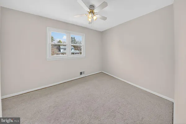 an empty room with a window and a fan