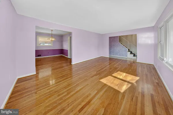 a view of a big room with wooden floor and windows
