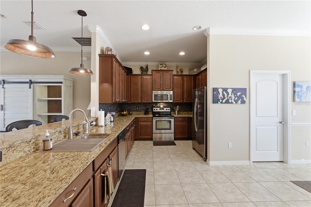 48 Evans Drive Palm Coast, FL 32164 - Photo 5 of 47 a kitchen with kitchen island granite countertop a refrigerator a sink a stove and oven