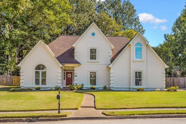 a view of house with garden and swimming pool