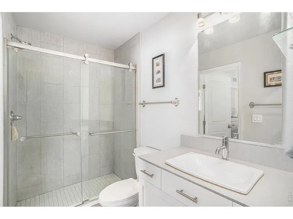 a bathroom with a sink toilet a mirror and shower