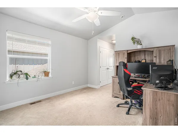 a view of a workspace with furniture and a window