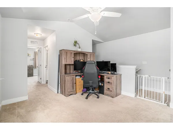 a view of a workspace with furniture and a ceiling fan
