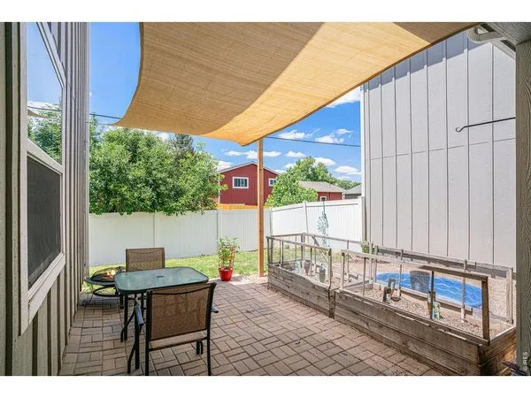 a backyard of a house with table and chairs