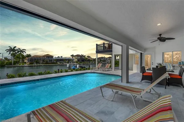 a swimming pool with outdoor seating and yard