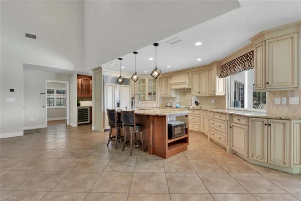 a large kitchen with kitchen island a sink counter and chairs