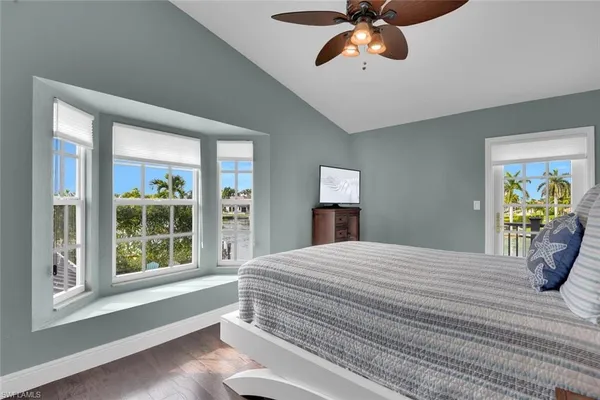 a bedroom with a bed and a large window