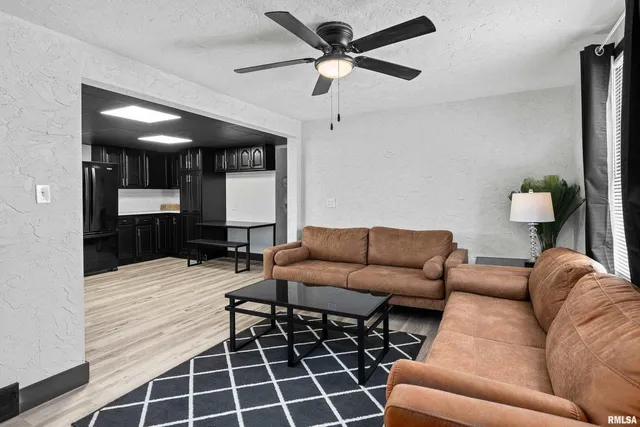 a living room with furniture a ceiling fan and a rug