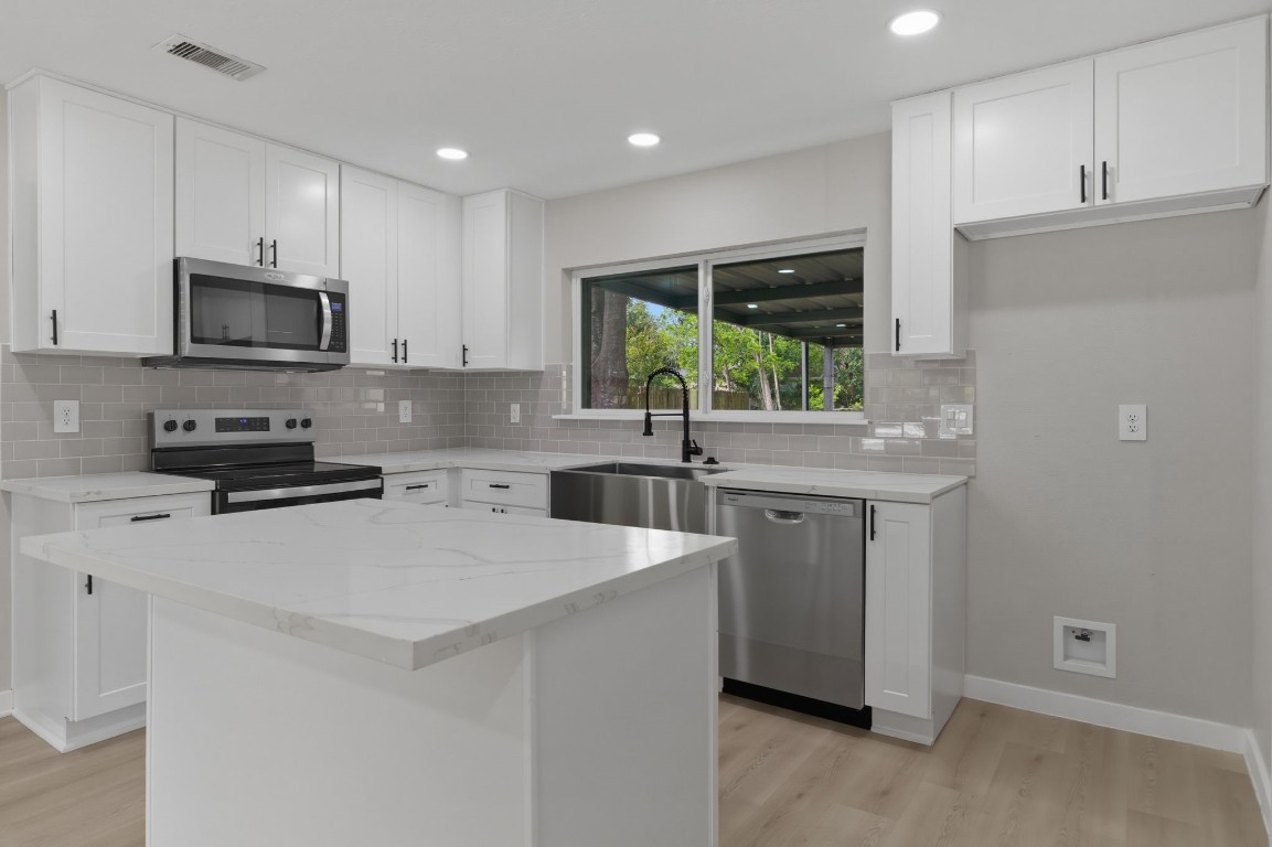 2208 Merle Street Pasadena, TX 77502 - Photo 8 of 26 a kitchen with stainless steel appliances granite countertop a sink a stove a refrigerator a microwave and cabinets