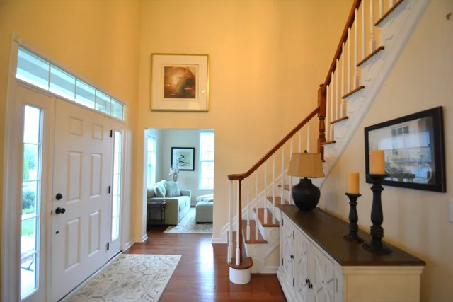 a view of a hallway with wooden floor and staircase