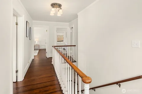 a view of a hallway with wooden floor and staircase